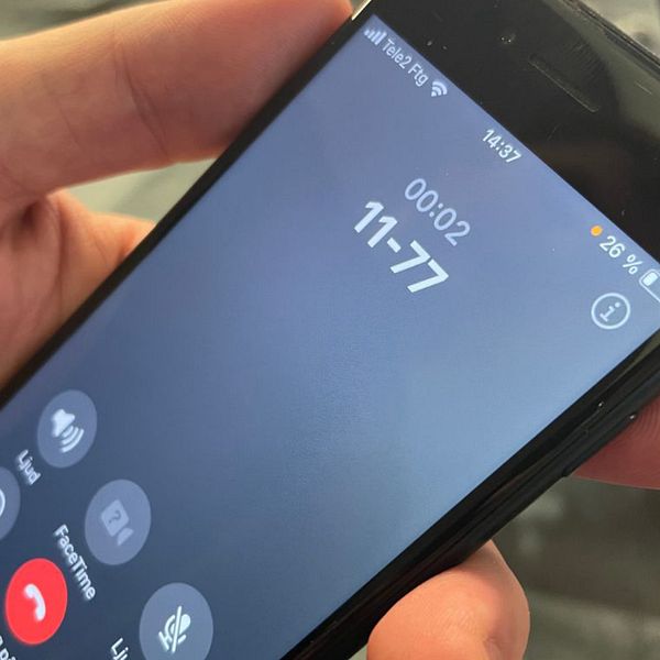 Hand håller telefon som ringer sjukvårdsupplysningen 1177 i