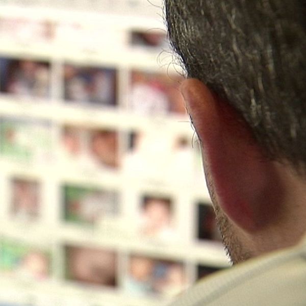 Person tittar på en datorskärm med många små suddiga bilder av ansikten.