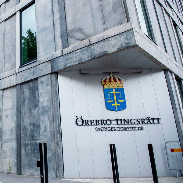Örebro tingsrätts byggnad med dess skylt och svensk vapensköld.