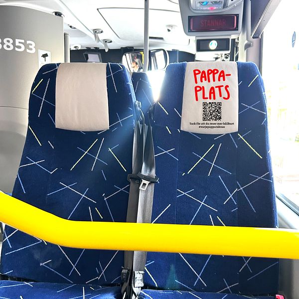 Bild på två bussäten där det ena sätet har texten pappa plats skriven på nackstödet.