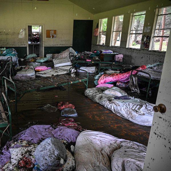 Översvämmat sovrum med blöta madrasser och sängar i oordning efter katastrof.