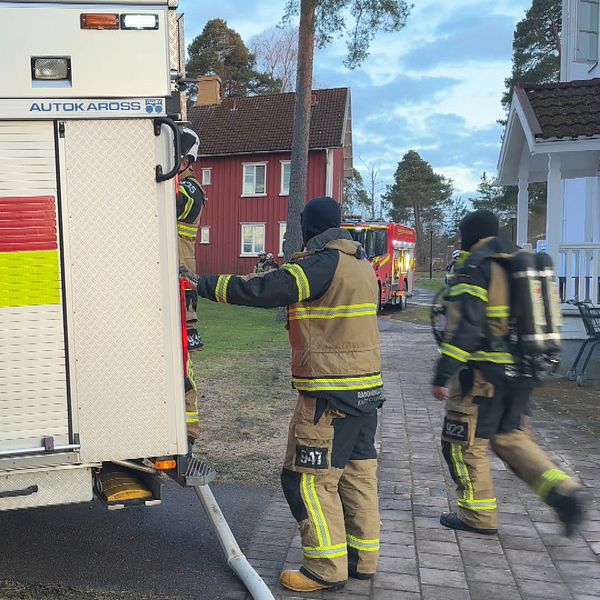 Ett gäng brandmän rör sig kring sitt utryckningsfordon