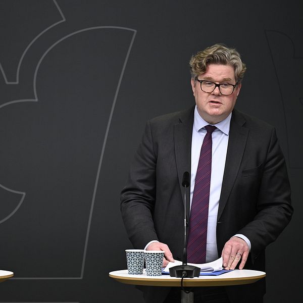En man och en kvinna framför en grå vägg.