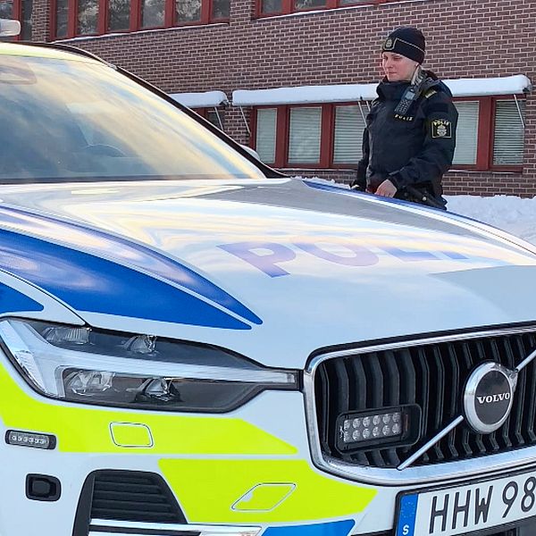 Polis som går mot en polisbil utanför Sollefteås polishus.