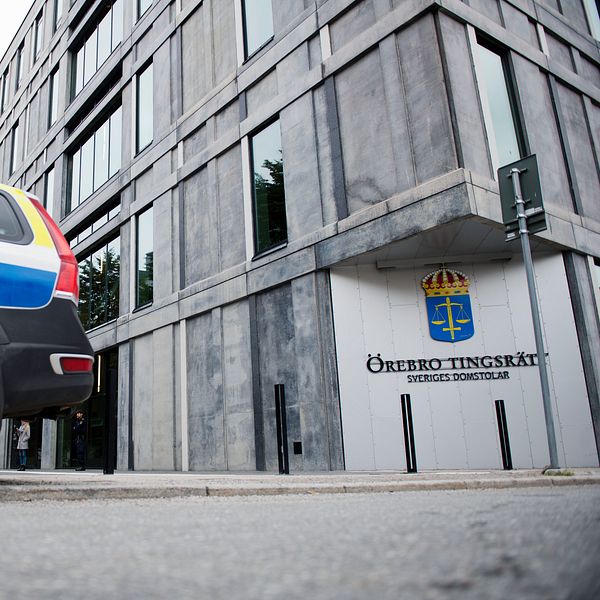 Polisbil utanför Örebro tingsrätts byggnad.