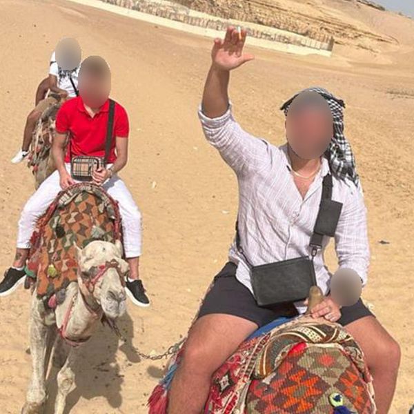 Två personer på kamelridning vid pyramiderna, kopplade till bedrägerihärva mot äldre.