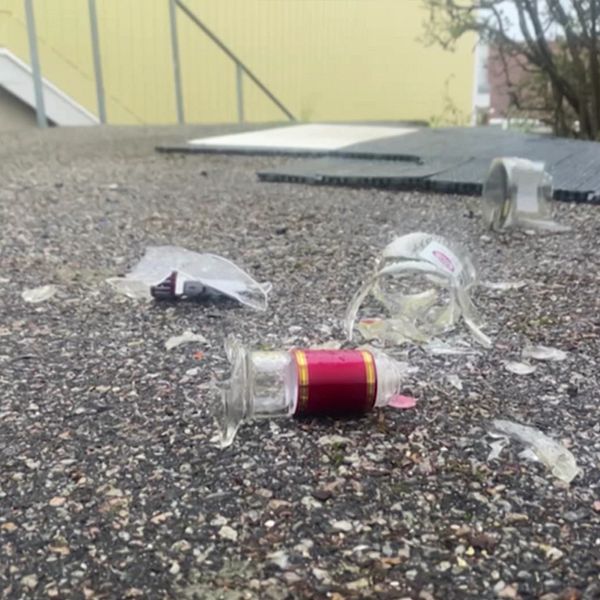 SVT:s reporter i Hässelby där en man misshandlades. Bild på krossat glas till höger.