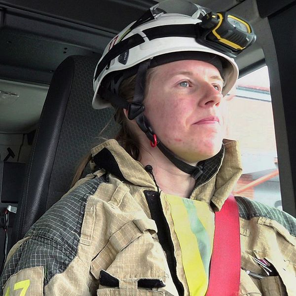 Brandmän i utryckningsfordon iförda hjälmar och skyddskläder.