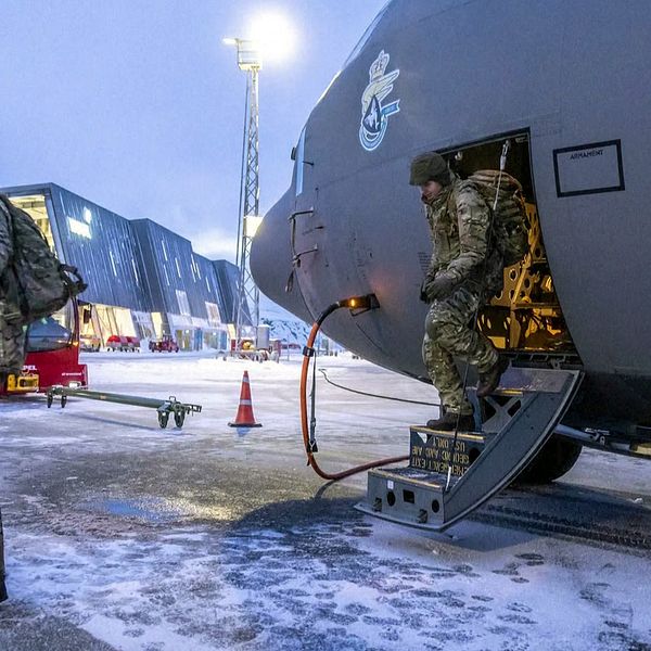Danska soldater kliver ur ett militärflygplan på snötäckt flygplats på Grönland.