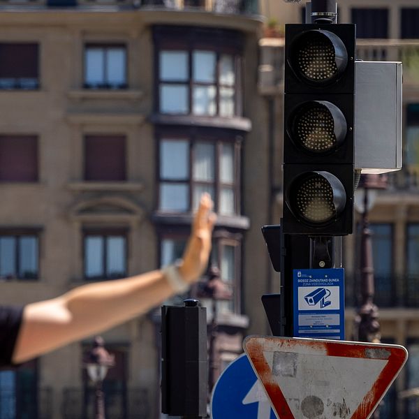 Trafikpolis dirigerar trafiken vid ett rött trafikljus i stadsmiljö.
