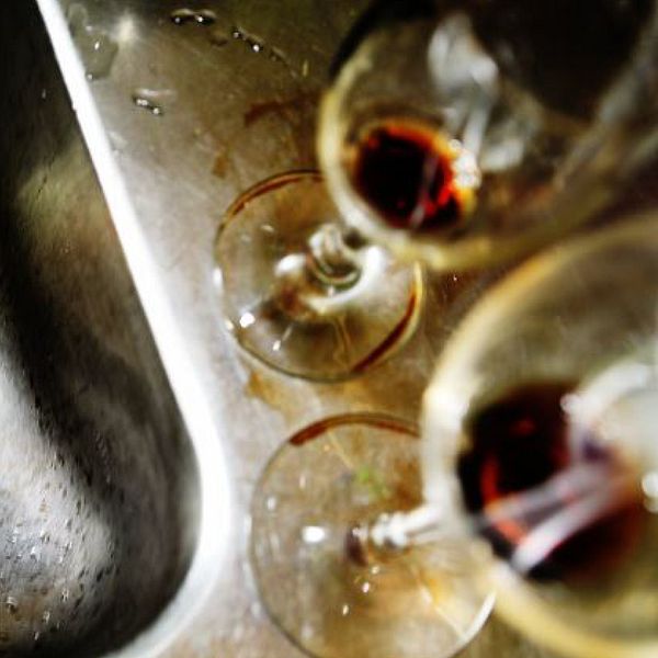 Bild på en vask med tom ölburk samt två inte helt urdruckna vinglas.