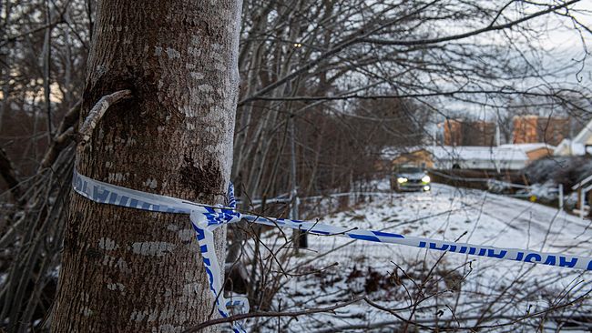 Ett polisavspärrningsband kring ett träd i snöig miljö. På platsen skadades en polisman.