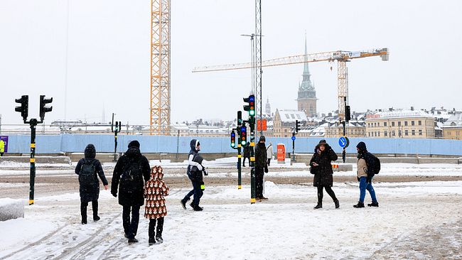 Människor promenerar i snöväder i Stockholm. Utsikt över Slussen i Stockholm.