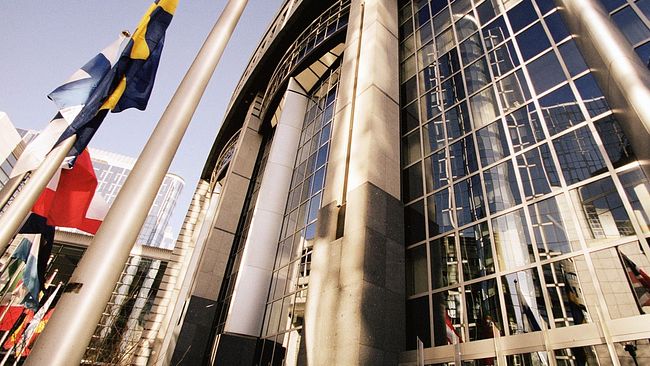Europaparlamentets byggnad i Bryssel, Belgien, med flaggor framför. 2024 är det val till Europaparlamentet.