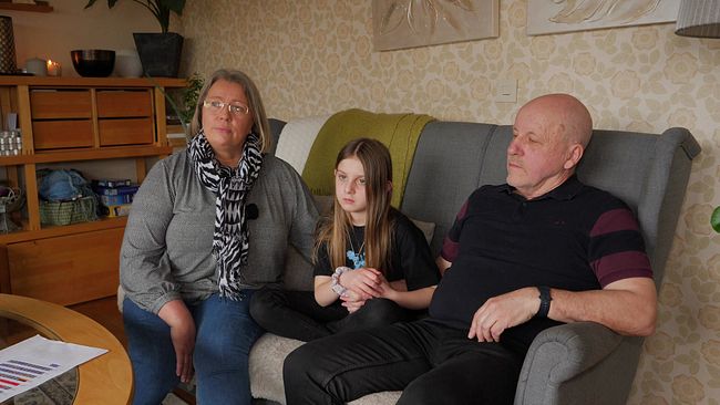Lisa, 9, ska utvisas till Albanien. Här sitter hon i en soffa med sina vårdnadshavare Paulina och Hans Backström.