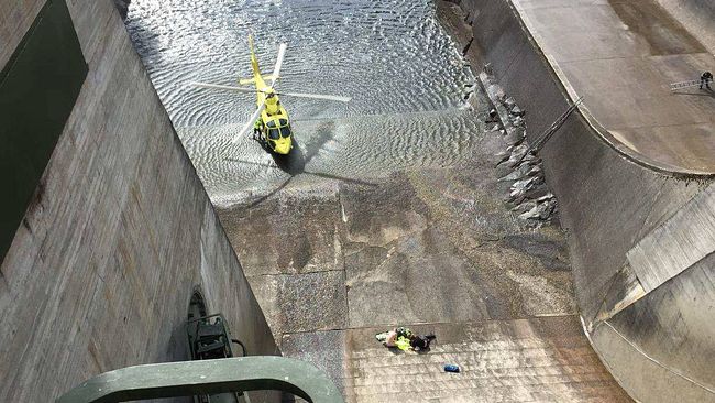 räddningshelikoptern och personal nere i dammkonstruktionen