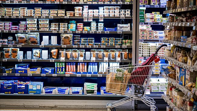 En kundvagn framför mejeriprodukter i en livsmedelsbutik.