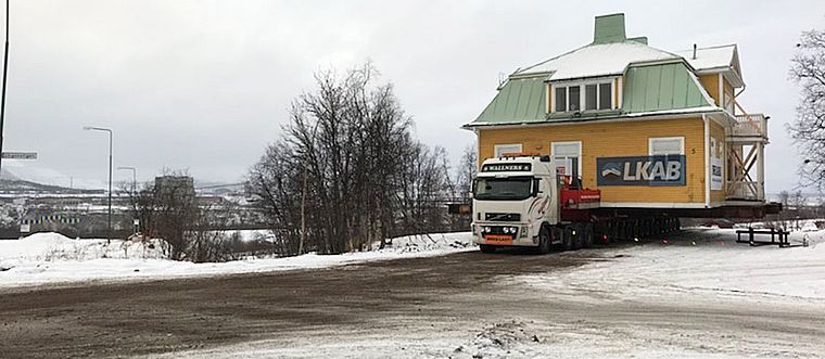 stort äldre trähus på lastbil