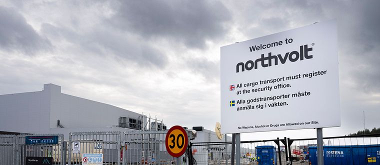 Northvolts fabrikområde med skylt och inhägnad under grå himmel.