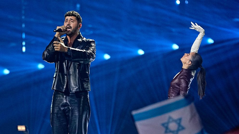 Eurovisionartist på scen med israelisk flagga i förgrunden
