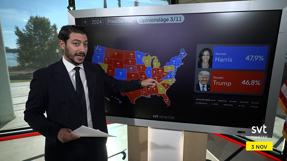 En person pekar på en stor skärm som visar en karta över USA med resultat för presidentvalet 2024.