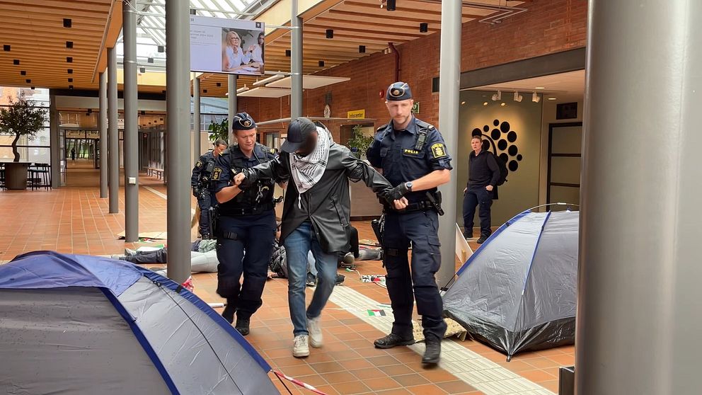 En man förs bort av polis