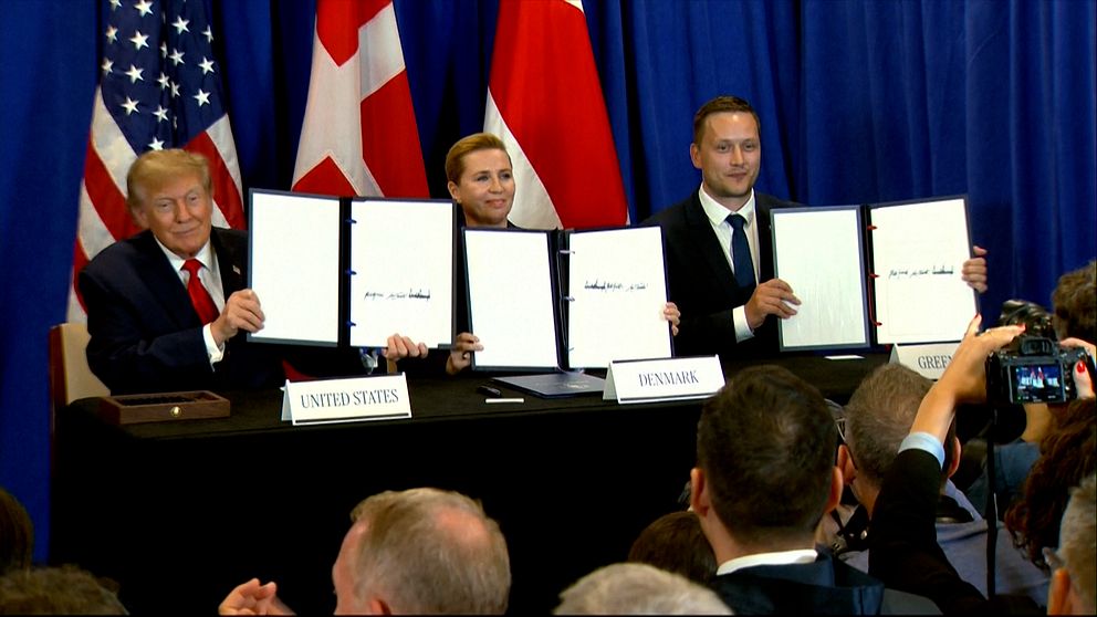 Donald Trump, Mette Frederiksen och Jens-Frederik Nielsen signerar avtalet vid podium
