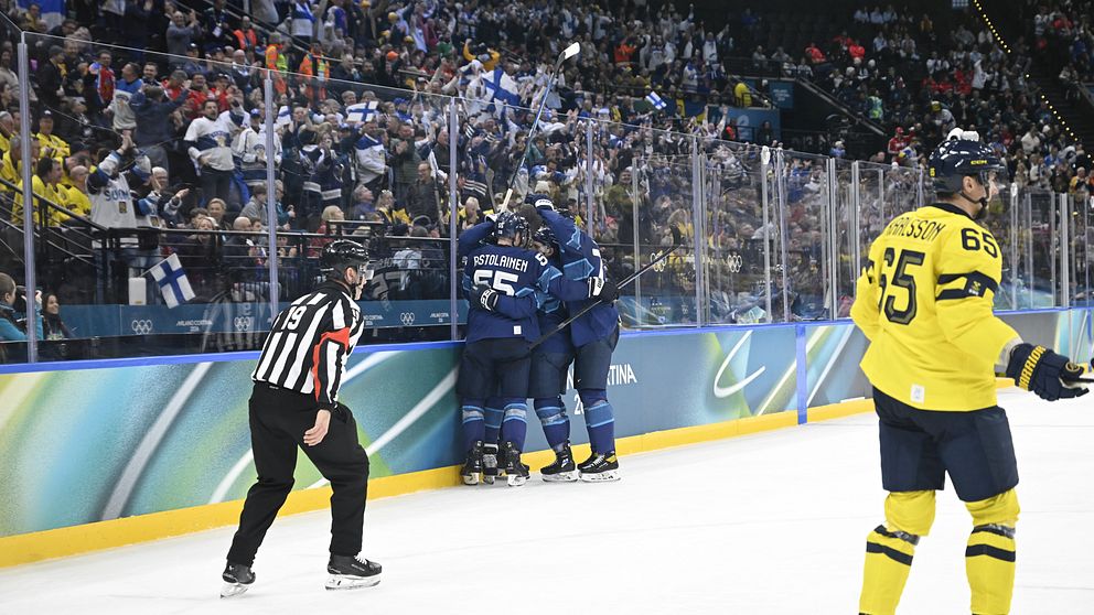Finska spelare firar mål i boxplay mot Sverige under ishockeymatch.