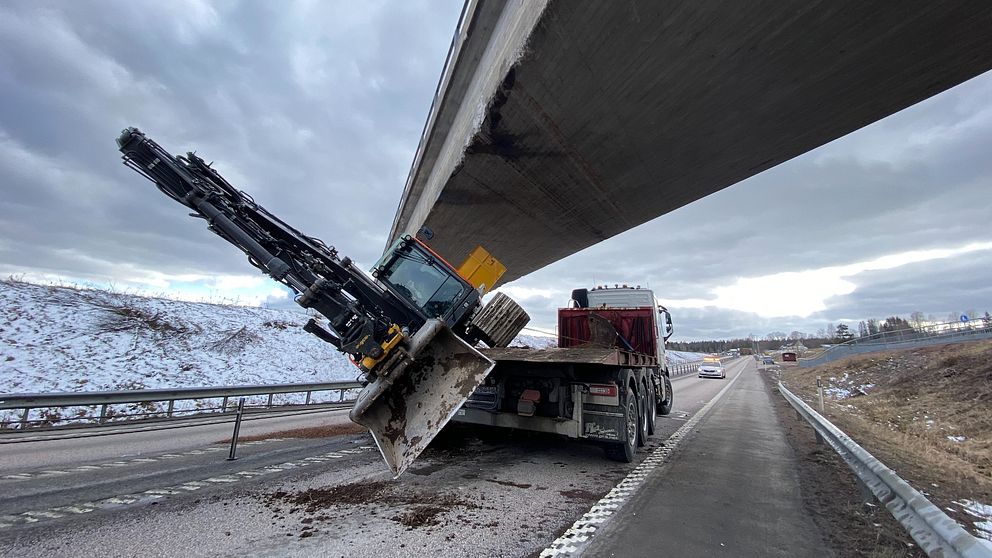 Lastbil med kran har kört in i bro på snöig motorväg.