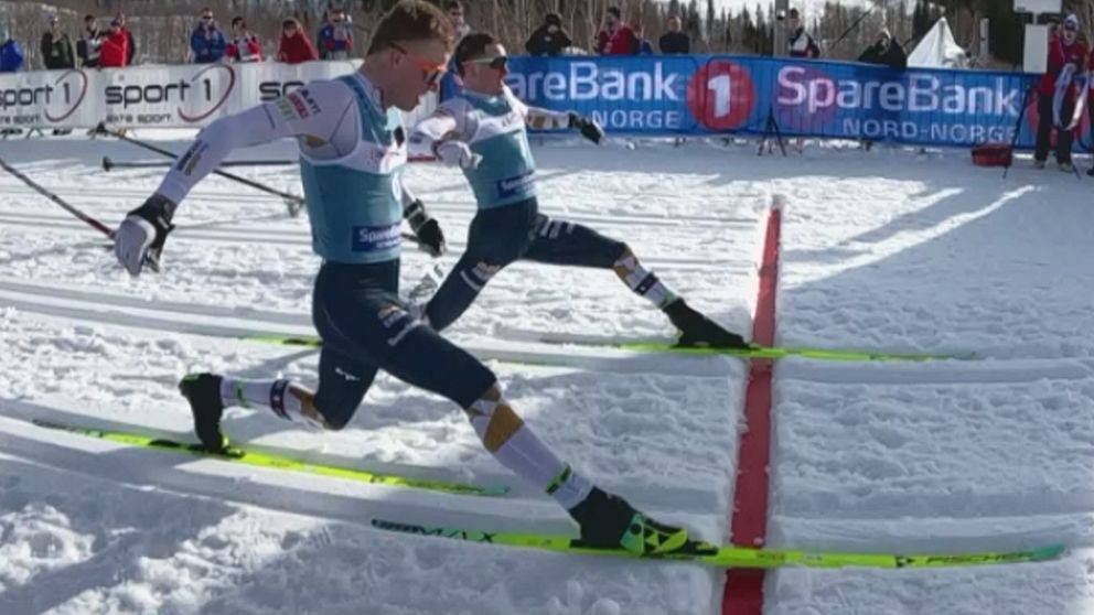 Två skidåkare spurtar mot mållinjen under en längdskidtävling.