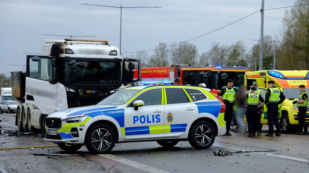 Olycksplats med polisbil, brandbil, lastbil och räddningspersonal.