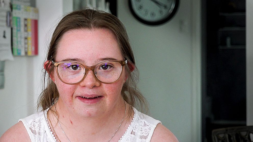 En bild på Hedvig Roos Rahmquist. Hon tittar in i kameran och ser glad ut.