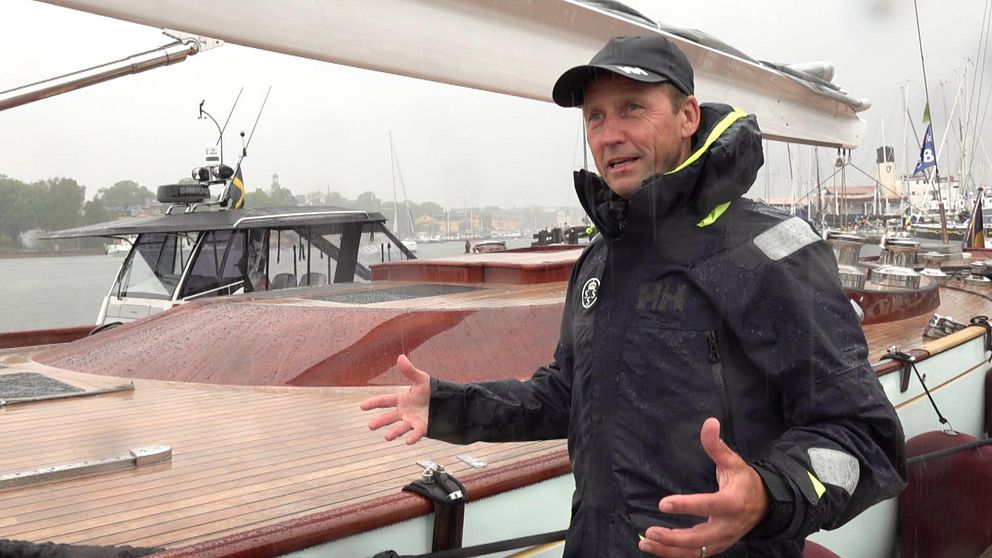 Steffan Rahm står framför en båt i regnet.