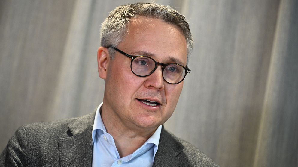 Johan Danielsson (S) i kostym framför grå bakgrund.