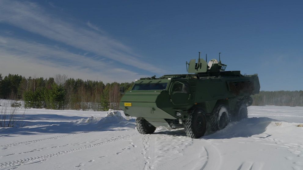 Patria pansarterrängbil kör på snötäckt väg i vinterlandskap