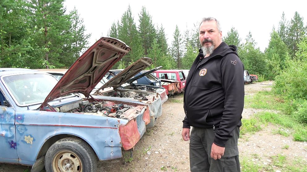 Flera sönderslagna bilar uppradade på motorklubben i Boden. Bredvid står Jörgen Nordgren, klubbens ordförande.,