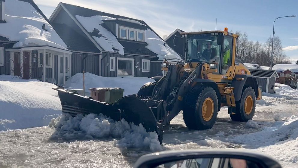 En traktor som forslar utan smältvatten från en villagata i Piteå.
