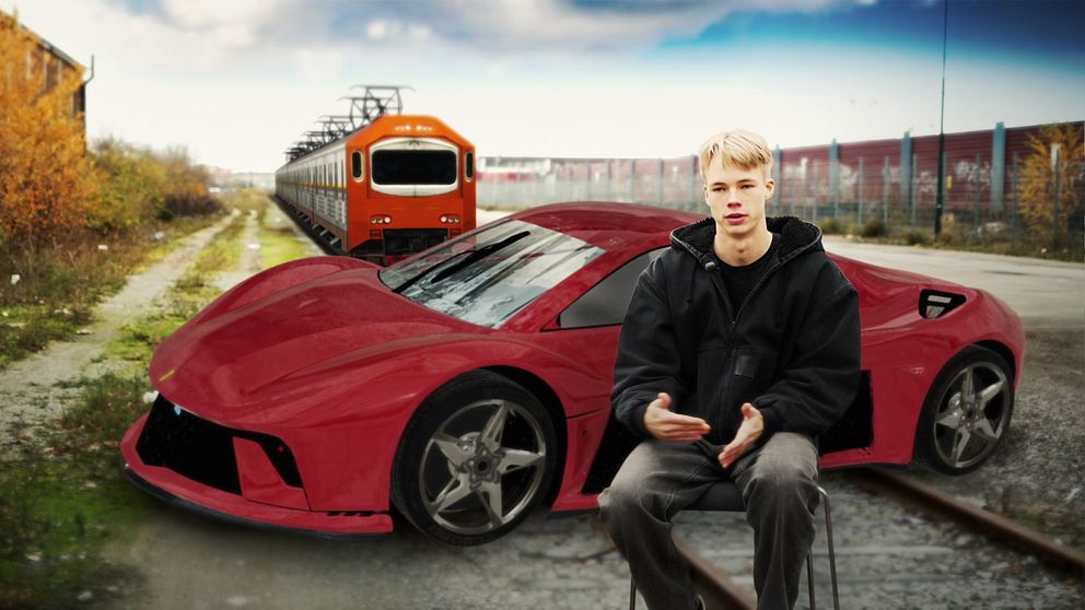 En man sitter på en stol framför en futuristisk rosa bil vid en järnväg, där en orange tågvagn står i bakgrunden.
