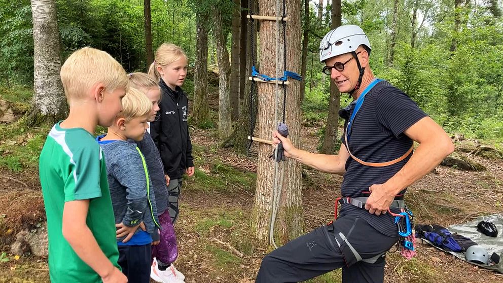 Nikolaj Lubanski instruerar fyra barn bredvid trädet
