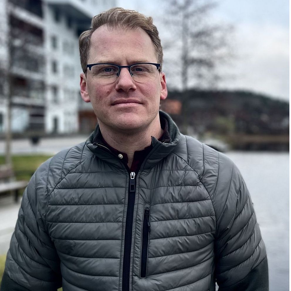 En man i jacka till vänster, Sebastian Aronsson  från socialdemokraterna, och en kyckling med få fjädrar till höger.