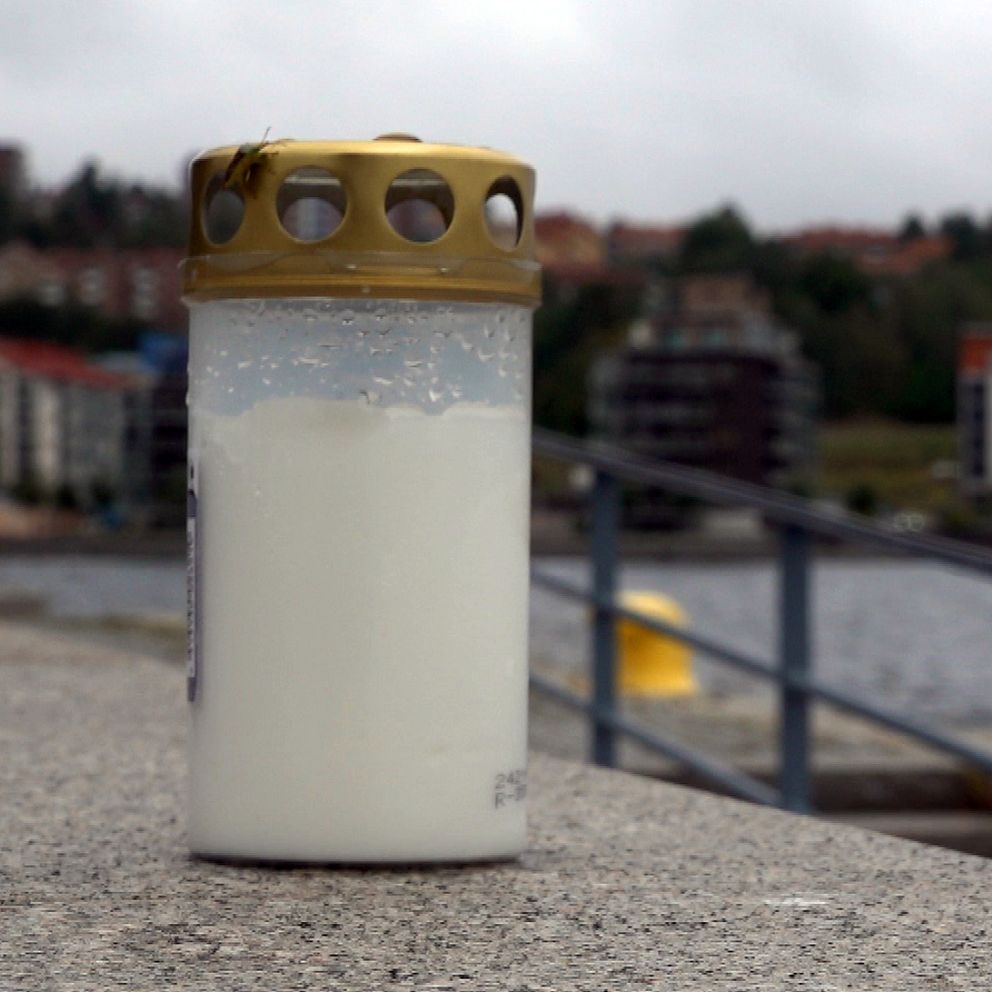 Bild på ett icke tänt gravljus som står på en mur intill platsen där mannen ska ha farit i vattnet vid kajen.