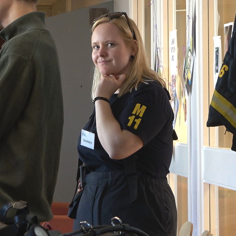 Branmannen Celine Renfors står i en skolkorridor och tittar in i kameran.