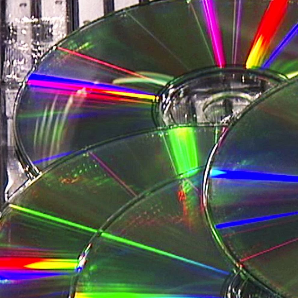 En delad bild som visar en uppsättning CD-skivor med reflekterande ytor på vänster sida, och en oskarp del av ett juridiskt dokument med rubriken ”Stämningsansökan” och en punkt om ”SEXUELLT OFRENDANDE” på höger sida.