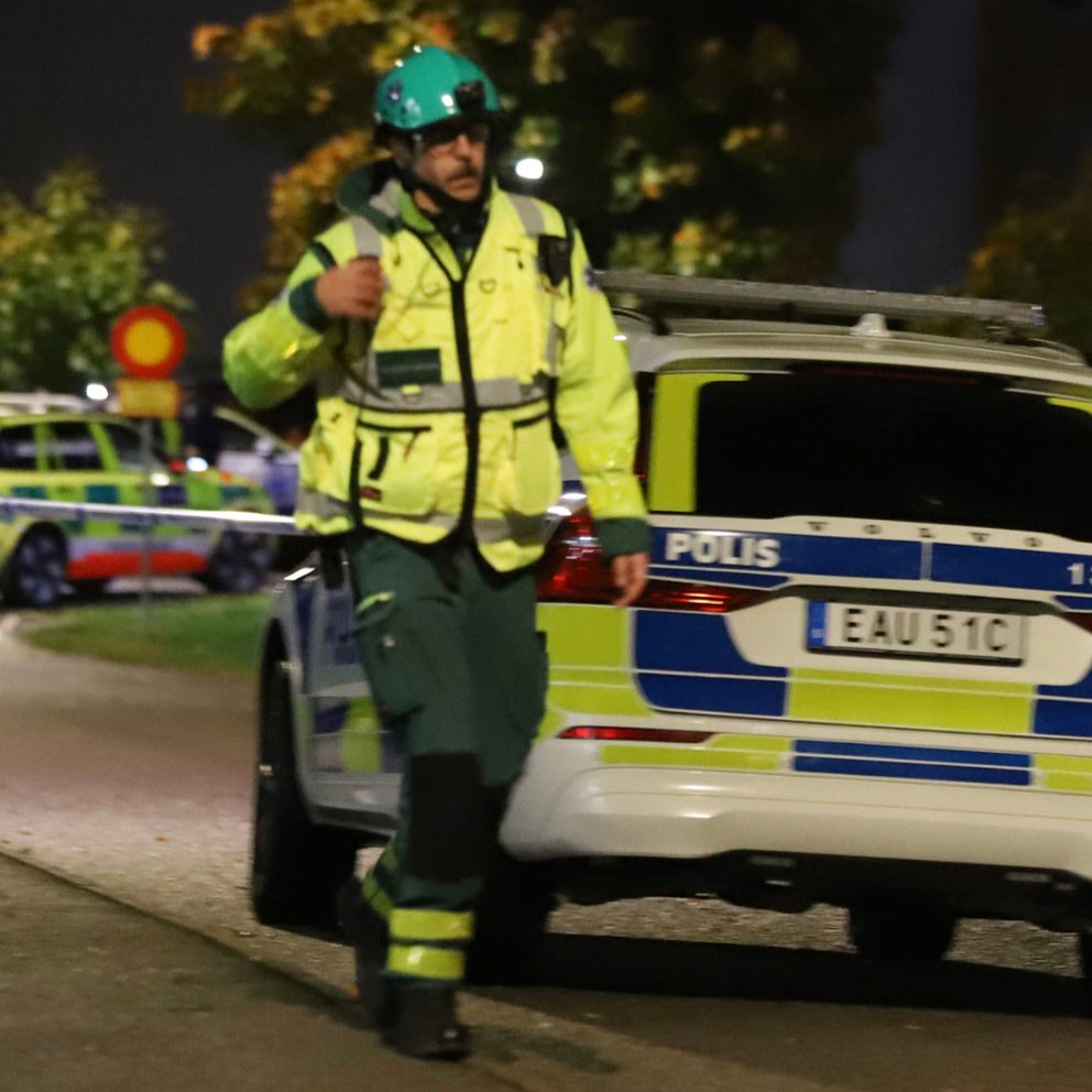 Sjukvårdspersonal vid polisbil och ambulans