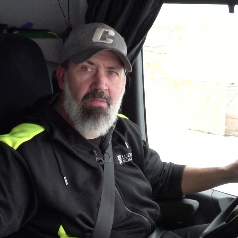 Thomas Hedman, som jobbar som snöröjare i Ludvika kommun sitter i förarhytten till plogbilen. han har keps och helskägg.