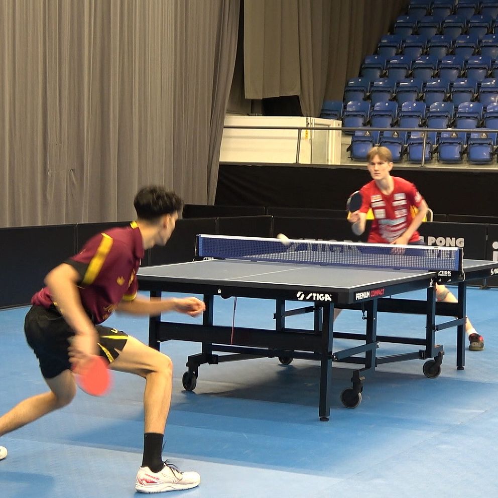 Två killar spelar bordtennis.