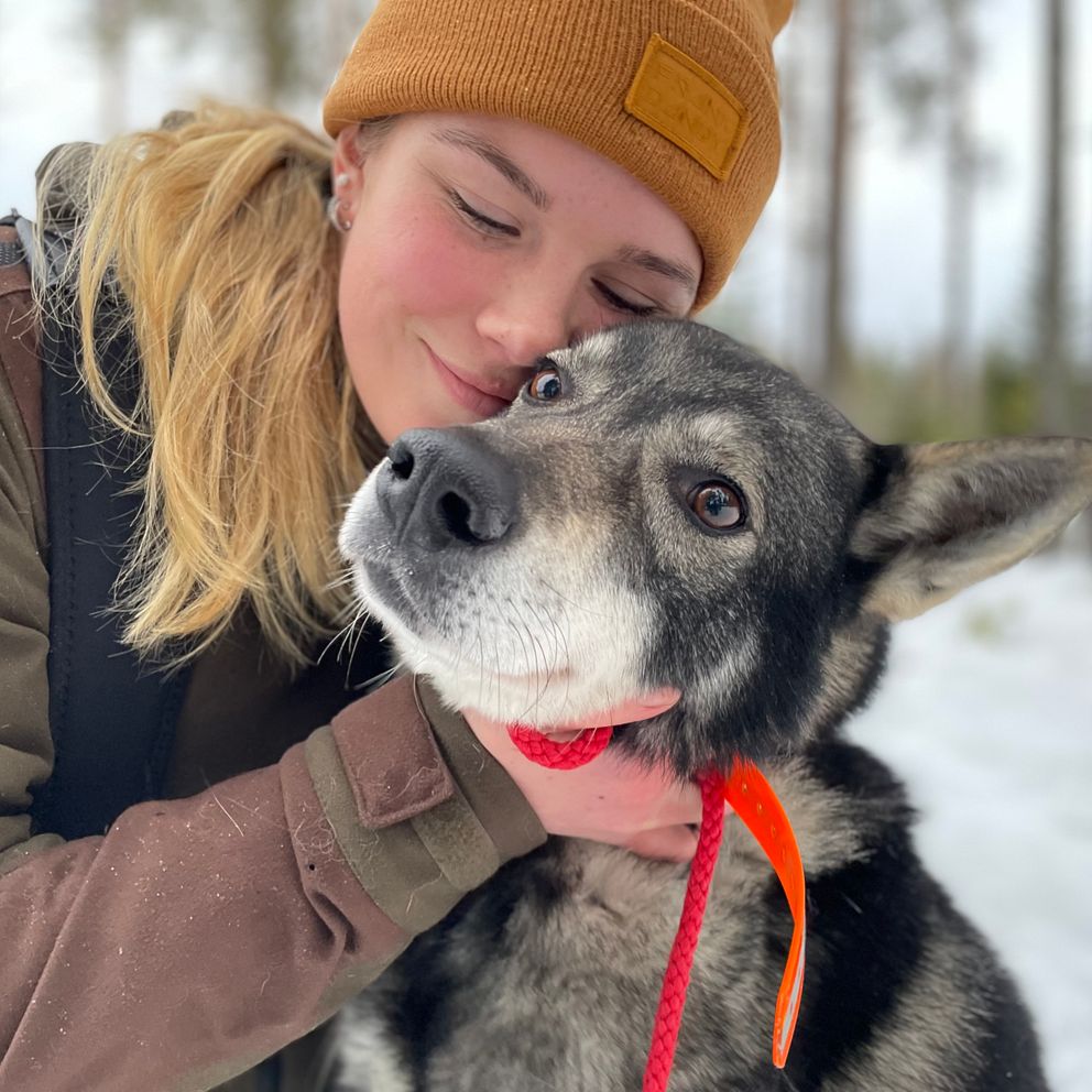 Wilma Karlsson i skogen kramar om sin jämthund Brage.