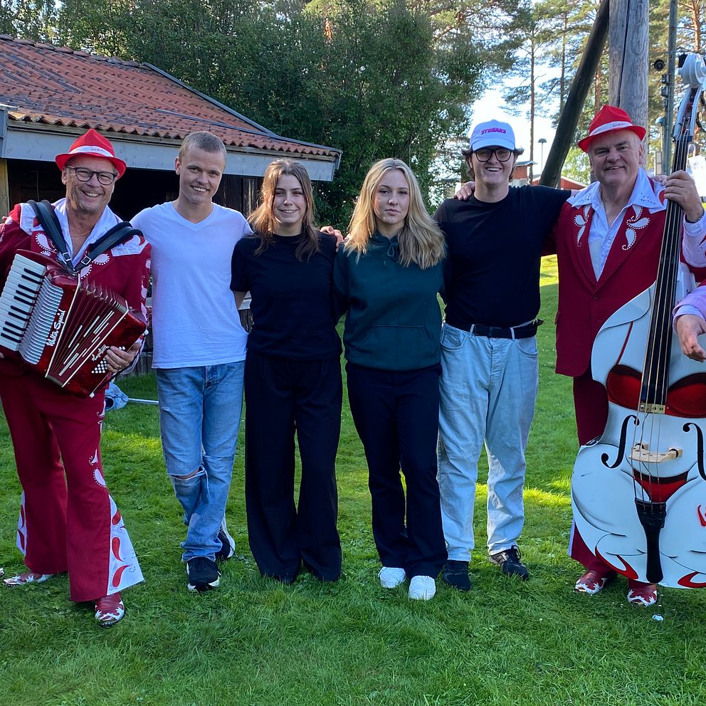 Bandet Larz-Kristers står uppställda i Orrskogens Folkpark tillsammans med fyra ungdomar som besöker dansbandsveckan i Malung.