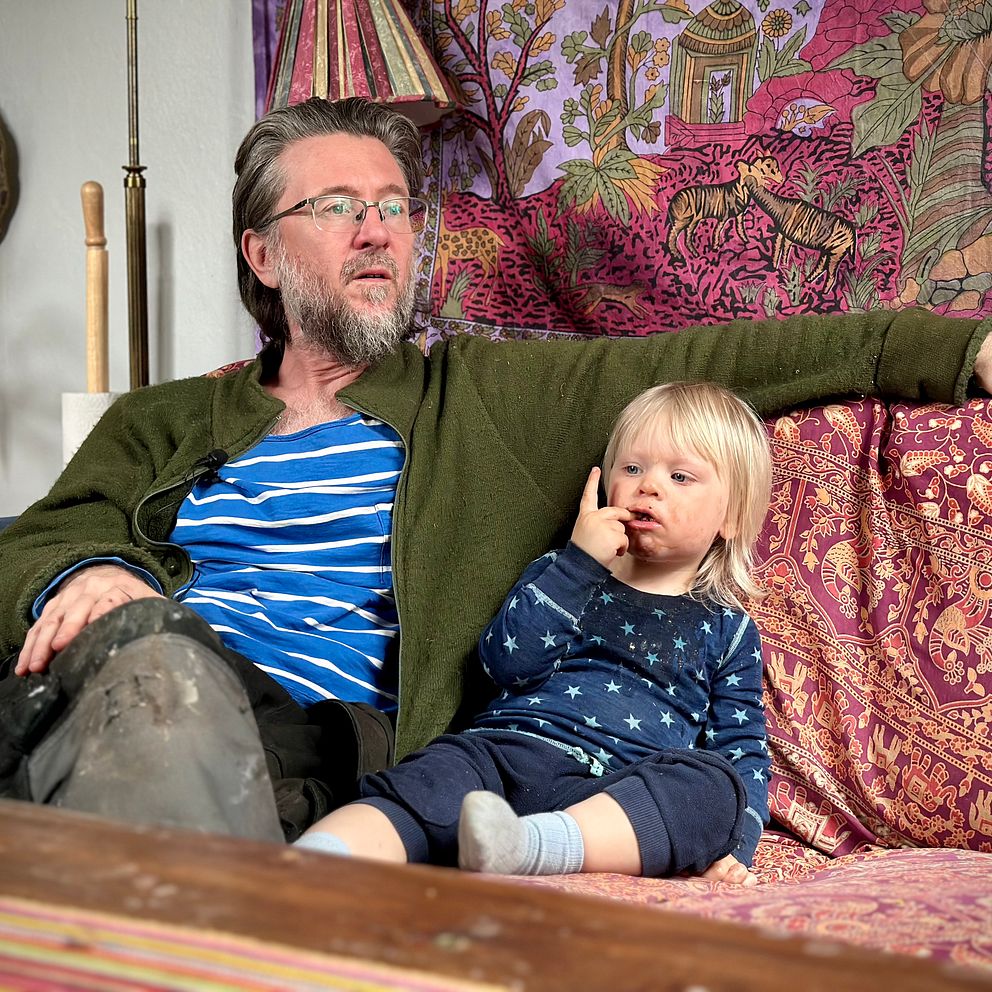 Mathias Viklund sitter på en soffa med sin tvååriga dotter.