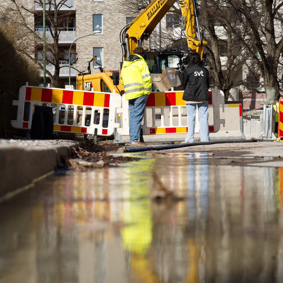 Bild på vatten längs med trottoarkanten utanför Rudbecksgymnasiet